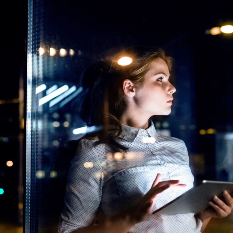Businesswoman with tablet working late at night.